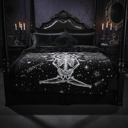 A black tapestry featuring a white celestial skeleton design with a sun, moon phases, and stars, hanging on a wall above a wooden floor with decorative vases and a picture frame.