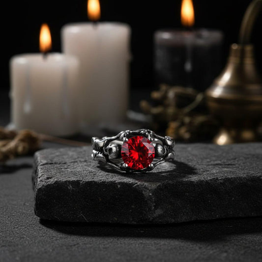 Silver ring with a red gemstone on a beige background