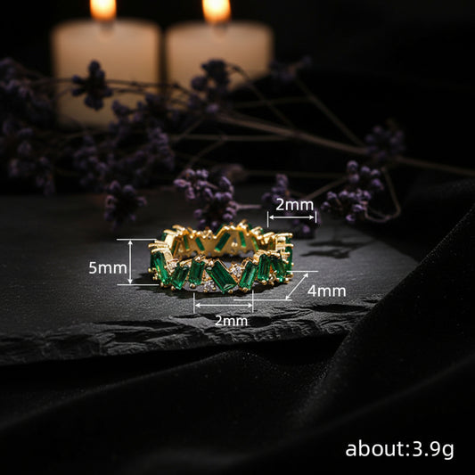 Gold bracelet with green gemstones and measurements on a neutral background
