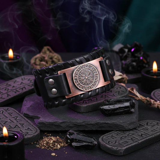 Black leather bracelet with a bronze Vegvisir pendant on a wooden surface.
