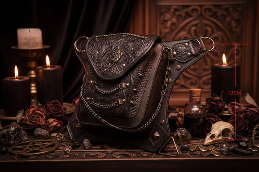 A black and white line art illustration of a small, highly detailed, ornate pouch or accessory with a triangular flap, layered straps, and chain details, accompanied by red dimension lines indicating a height of 12CM on a white background.