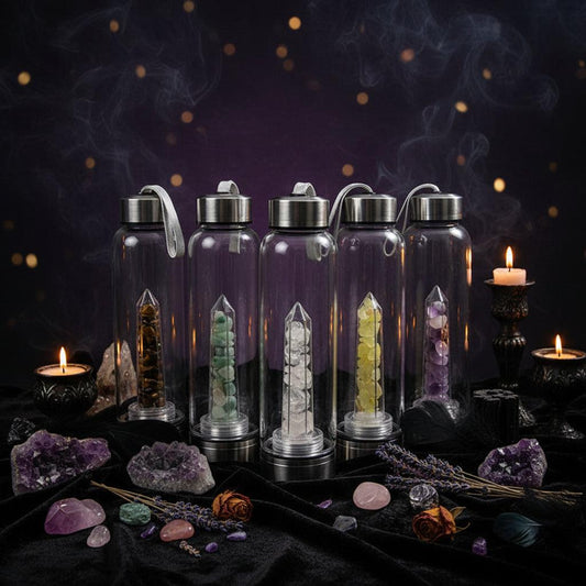 Set of clear glass bottles with metal caps, filled with various colored stones on a light gray background.