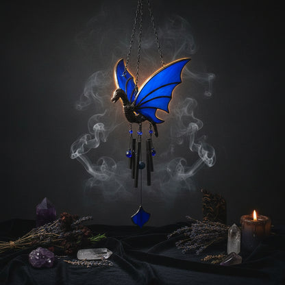 A stained glass dragon figurine with vibrant blue wings and a dark gray body, shown alongside two circular inset photos demonstrating its use as a window accent in a garden setting and held in hands.
