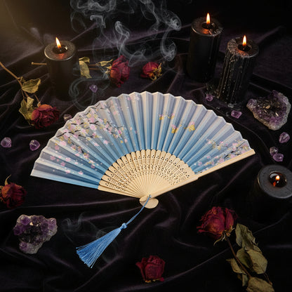 Traditional folding fan with floral design on a light background