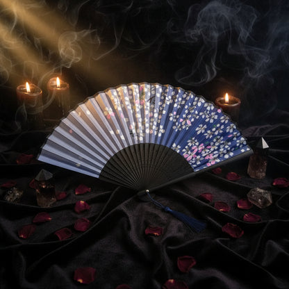 Blue and black fan with floral design on a white background with pink flowers
