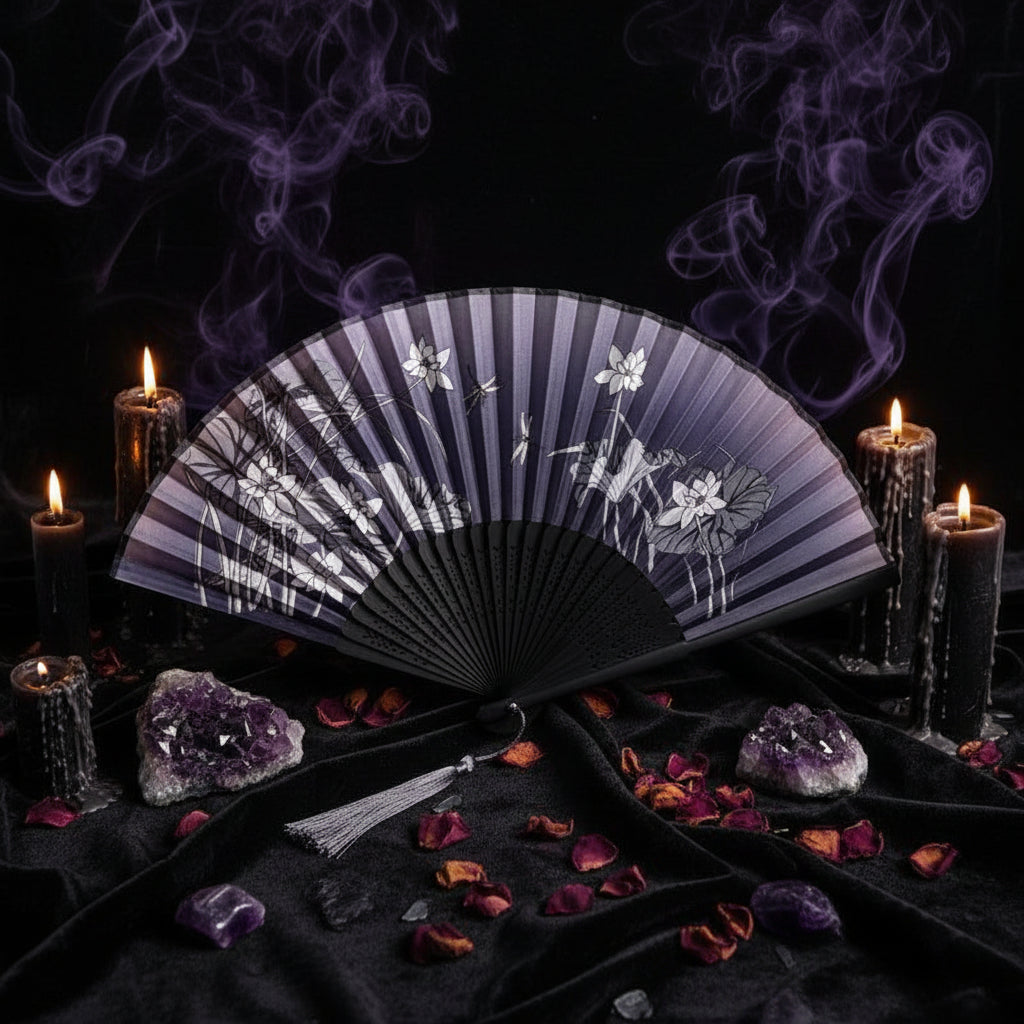 Black hand fan with floral design on a white background with pink flowers