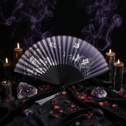Black hand fan with floral design on a white background with pink flowers