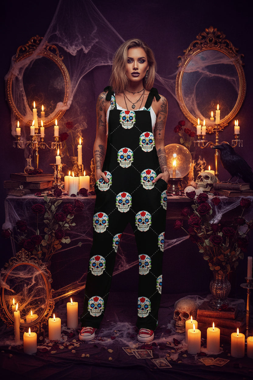 A woman modeling a black sleeveless jumpsuit with a colorful sugar skull print, styled with a white tank top underneath and red sneakers, standing in a bright indoor setting.