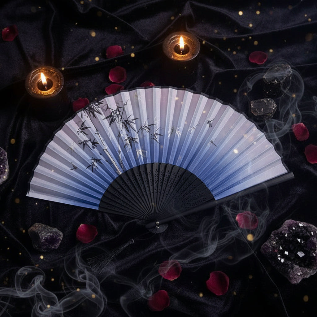 Traditional Chinese folding fan with black and white design on a light background with pink flowers.
