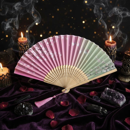 Colorful folding fan with floral decorations on a light background