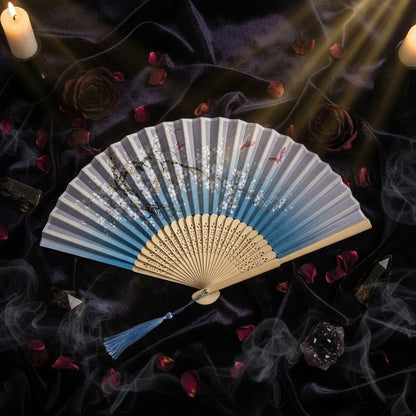 Handheld fan with artistic design on a white background with pink flowers