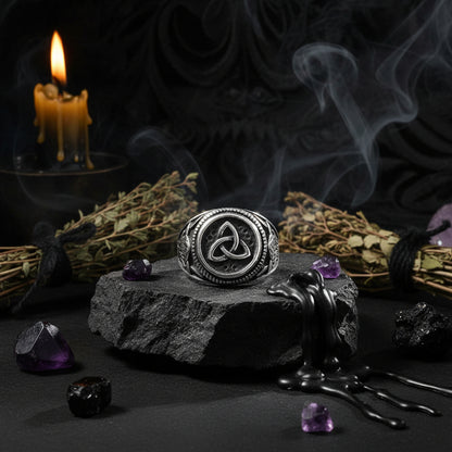 Silver ring with a Celtic knot design on a black background
