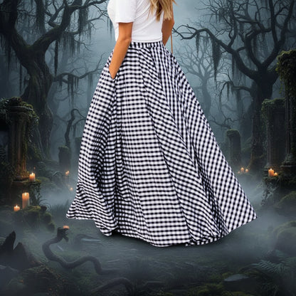 Person wearing a long black and white checkered skirt on a paved street.