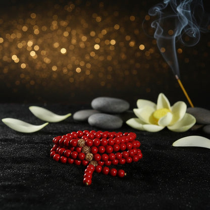 A coiled strand of red round beads with three textured gold spacer beads, displayed on a dark textured background.