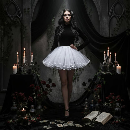 A white tutu skirt displayed on a white dress form mannequin stand in a bright, white-themed room with a chair and cabinet in the background.