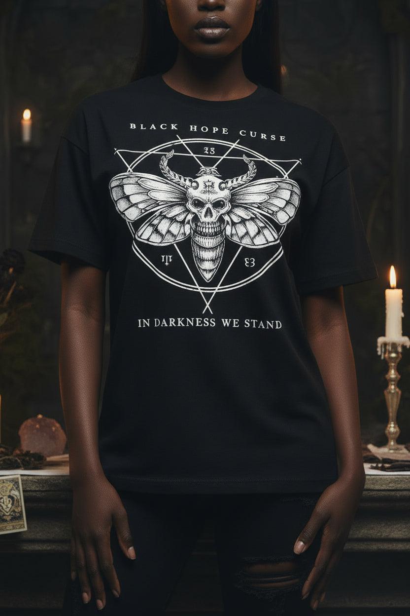 Black t-shirt with a graphic design featuring a skull and wings on a mannequin against a white background.