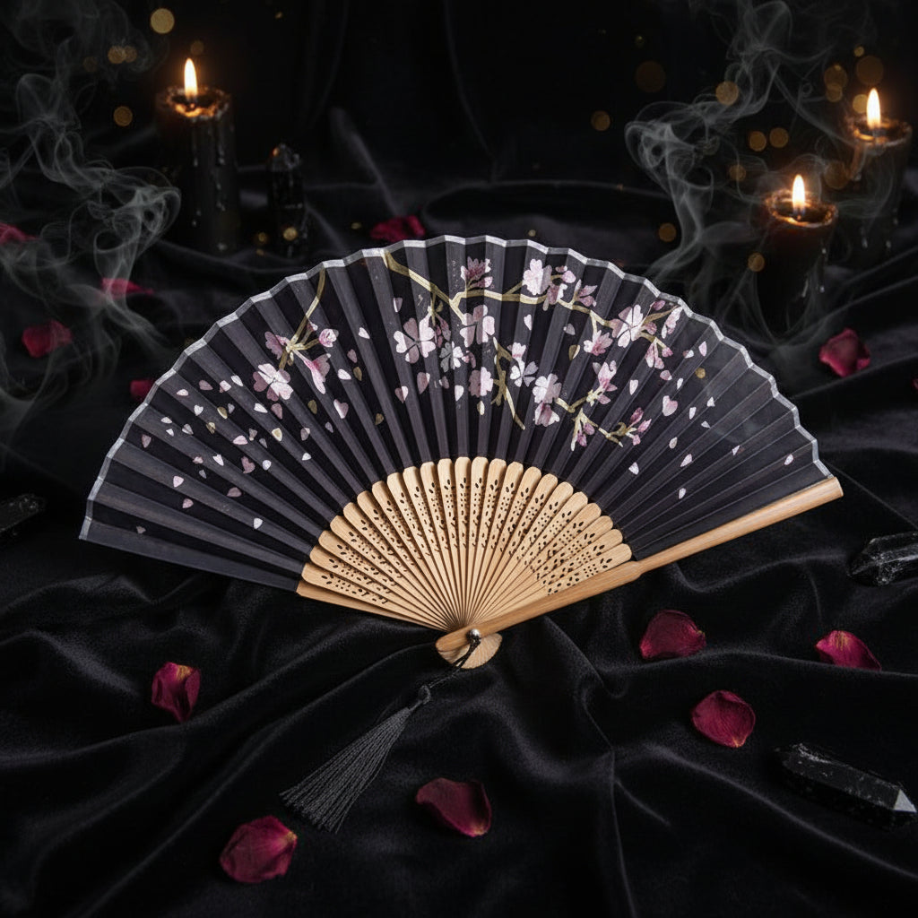 Handheld fan with floral design on a white background with pink flowers
