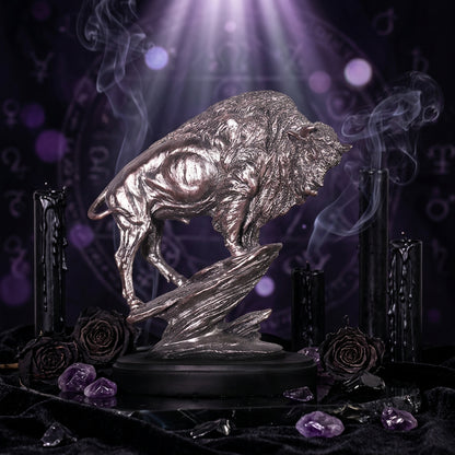 Silver buffalo statue on a dark base against a blurred indoor background