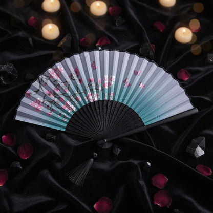 Traditional folding fan with cherry blossom design on a white background