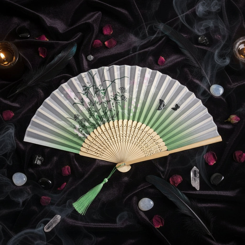 Traditional folding fan with floral design on a white background with pink flowers.