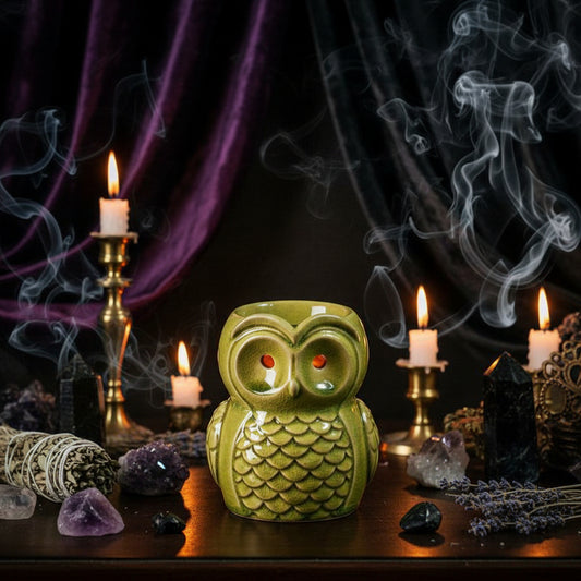 Green owl-shaped candle holder on a wooden surface with a blurred background