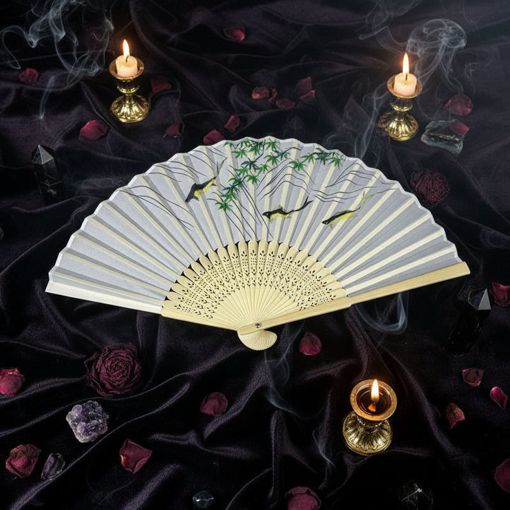 Handheld fan with floral design on a white tray with pink flowers