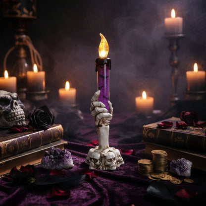 Decorative candle with a skull base on a table with Halloween decorations in the background.