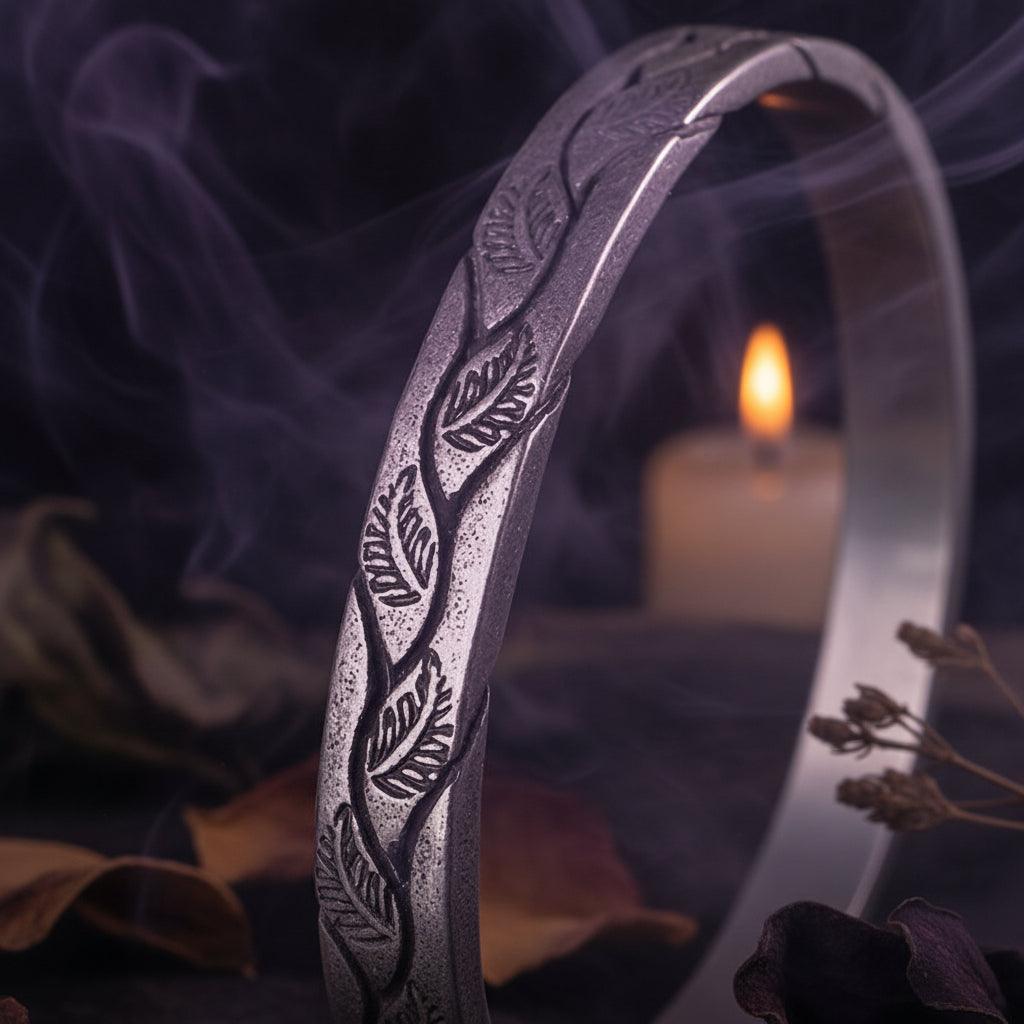 Silver bracelet with leaf pattern on a black background