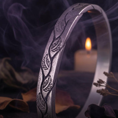 Silver bracelet with leaf pattern on a black background