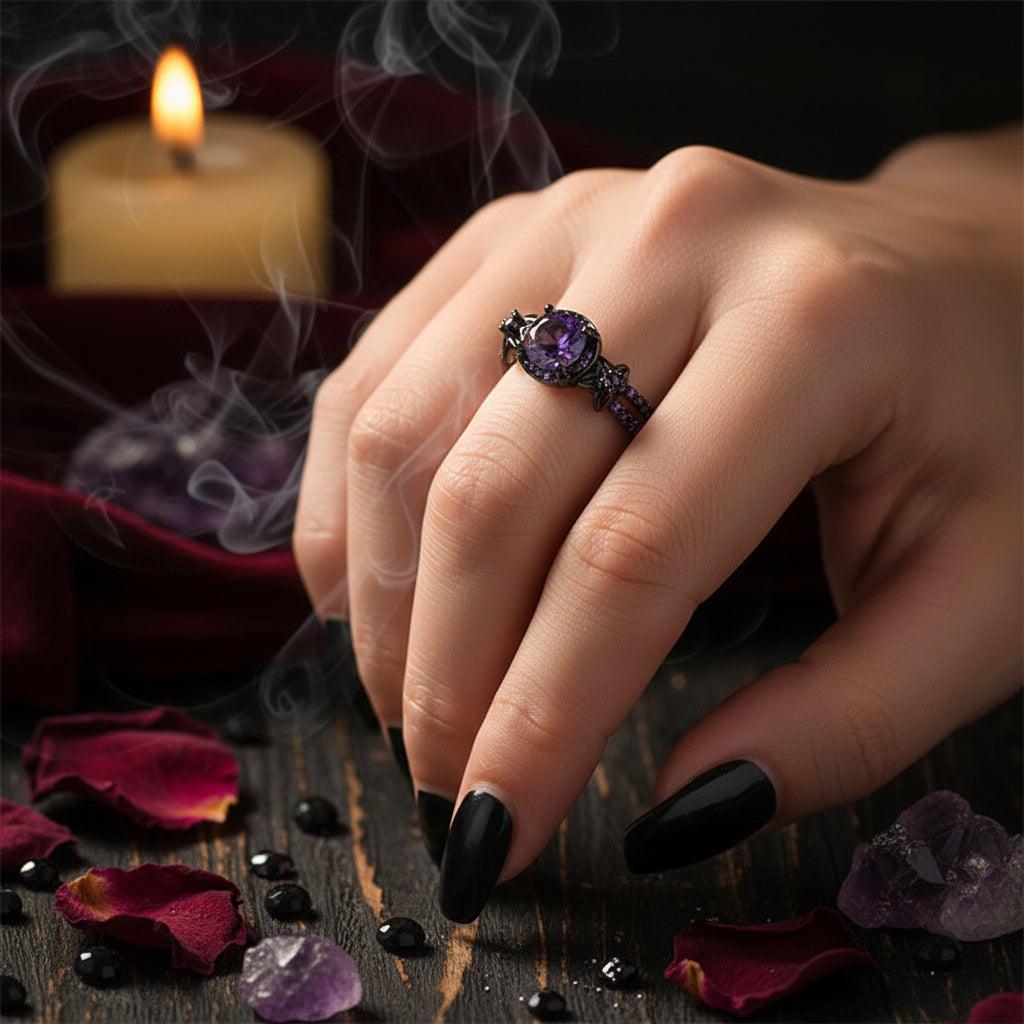 Purple gemstone ring on a finger against a neutral background