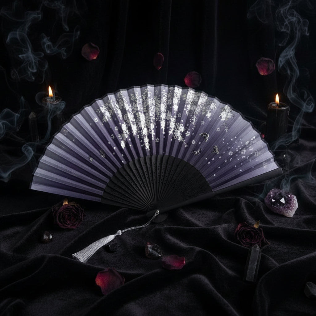 Black folding fan with decorative design on a white background with pink flowers