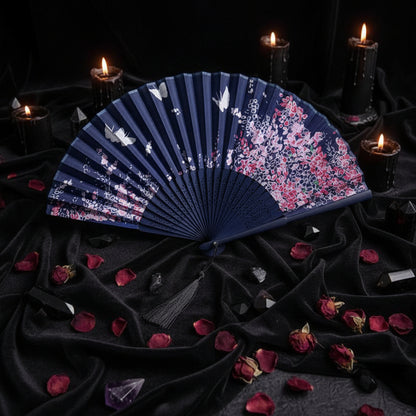 Blue floral-patterned fan on a white background with pink flowers