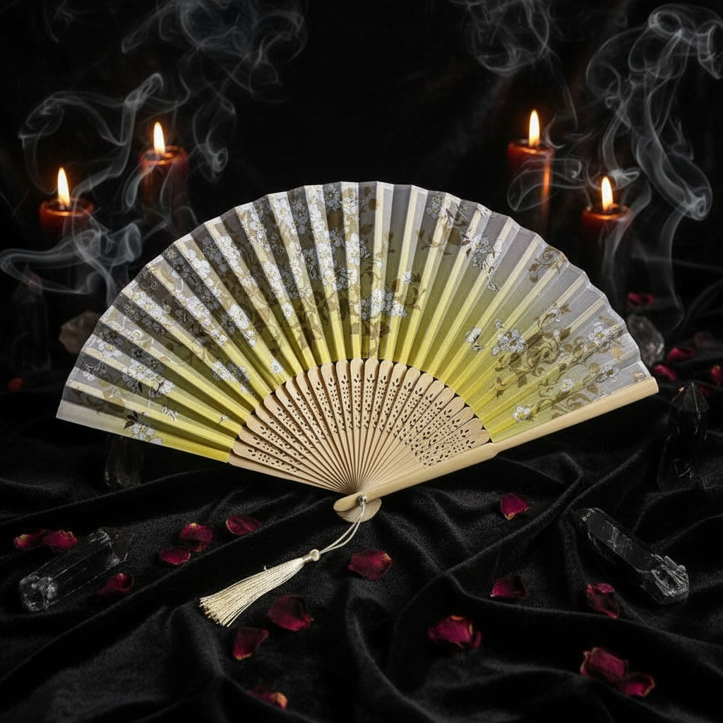 Decorative folding fan with floral design on a light background with pink flowers.