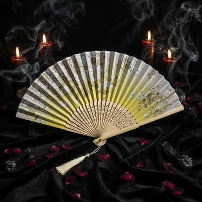 Decorative folding fan with floral design on a light background with pink flowers.
