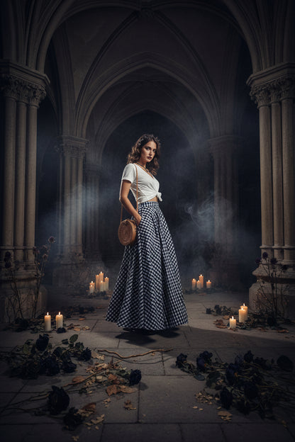 Person wearing a blue and white checkered skirt with a white top and holding a round woven bag on a neutral background.