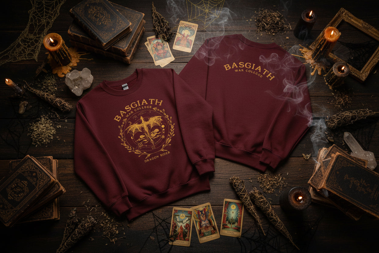 Two maroon sweatshirts with gold designs on hangers against a white background