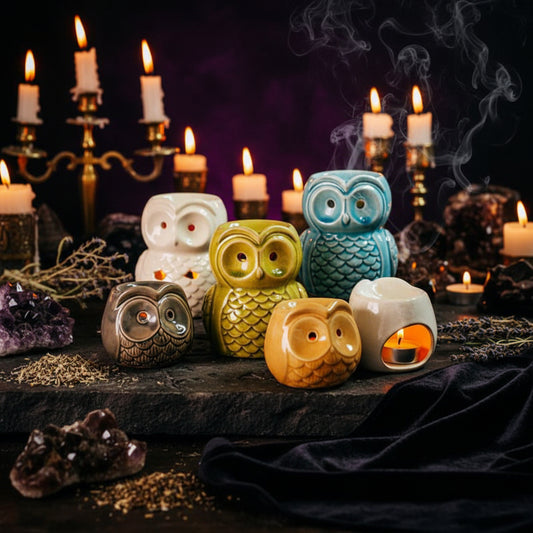 Set of colorful owl-shaped candle holders on a wooden surface.