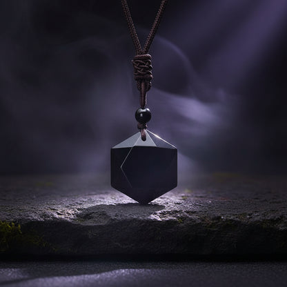 Black geometric pendant on a dark background