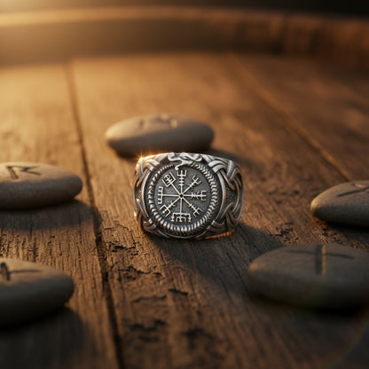 A silver-toned Viking-style ring featuring a central Vegvisir compass motif surrounded by Norse runes, with a braided knotwork band on a light gray background.