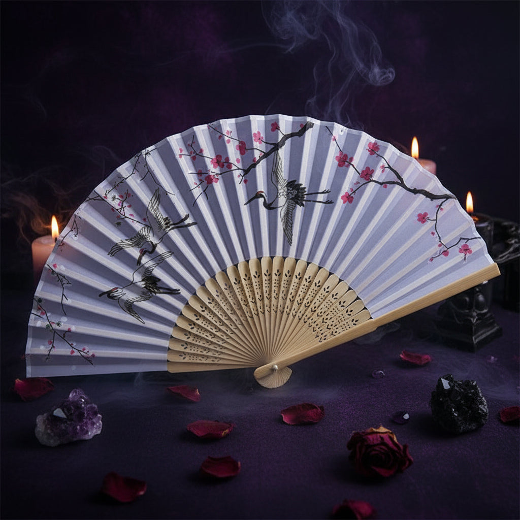 Handheld fan with bird and cherry blossom design on a light blue background