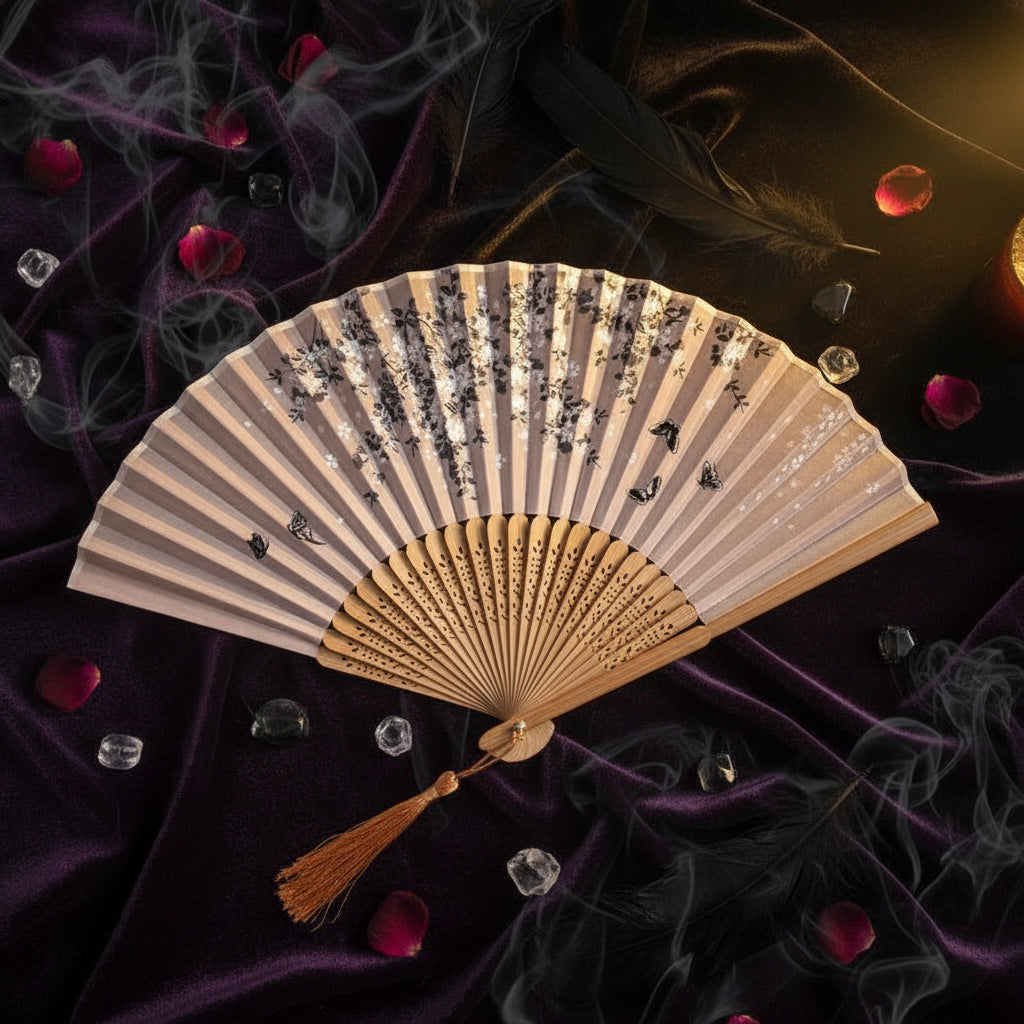 Traditional folding fan with floral design on a white background with pink flowers.
