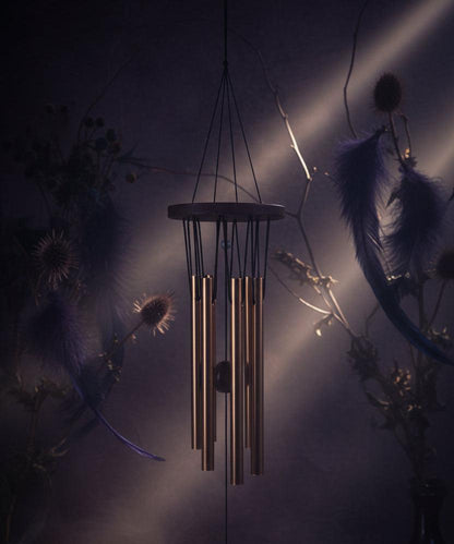 Decorative wind chime with wooden top and metal tubes on a white background