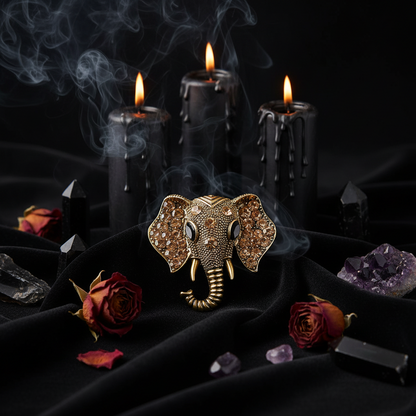 Gold elephant head brooch with gemstones on a white background