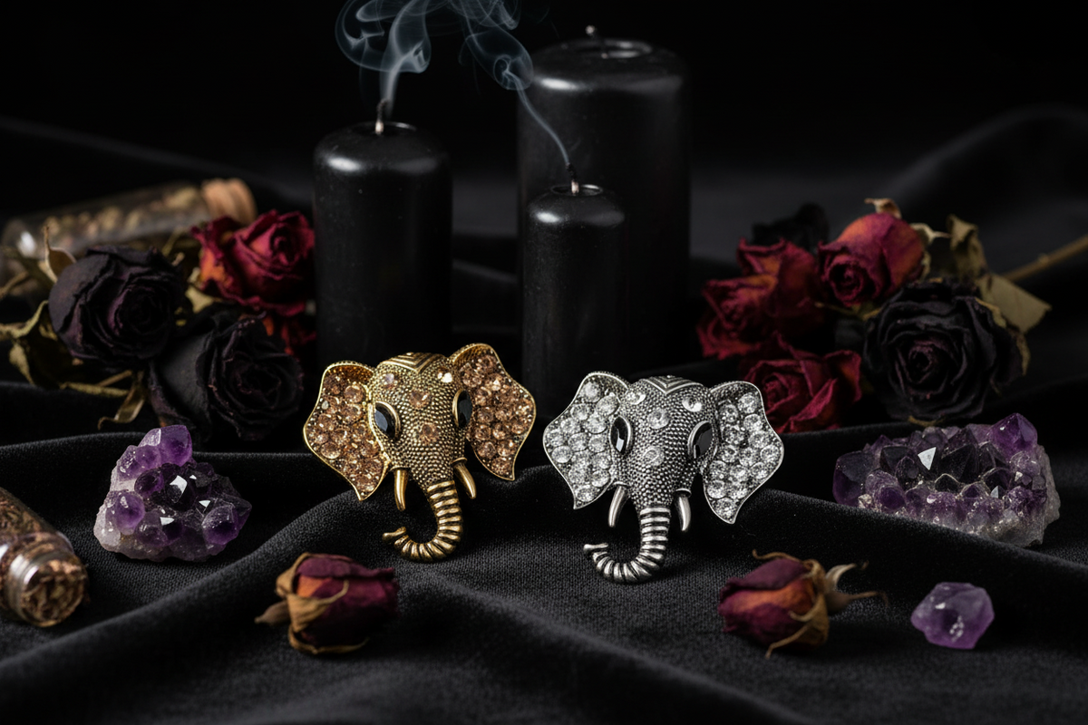 Two elephant-shaped brooches, one gold and one silver, on a white background.