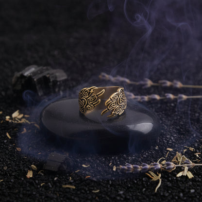 Gold Celtic knot ring on a black stone surface