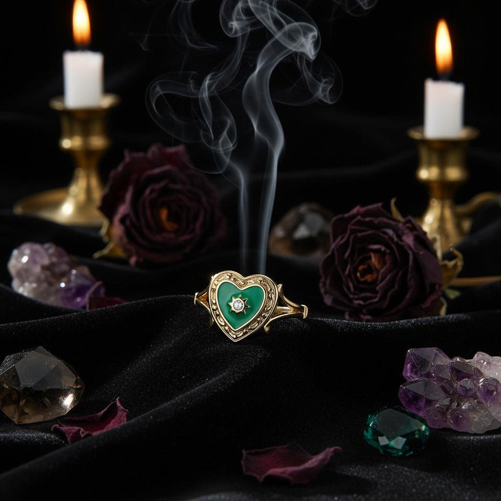 Gold ring with a green heart-shaped gem and diamond on a white background