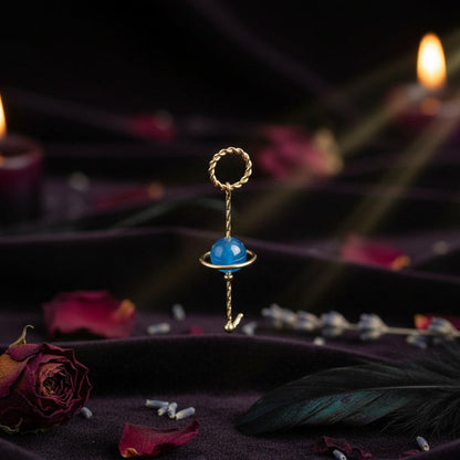 Gold ring with a blue gemstone on a white background