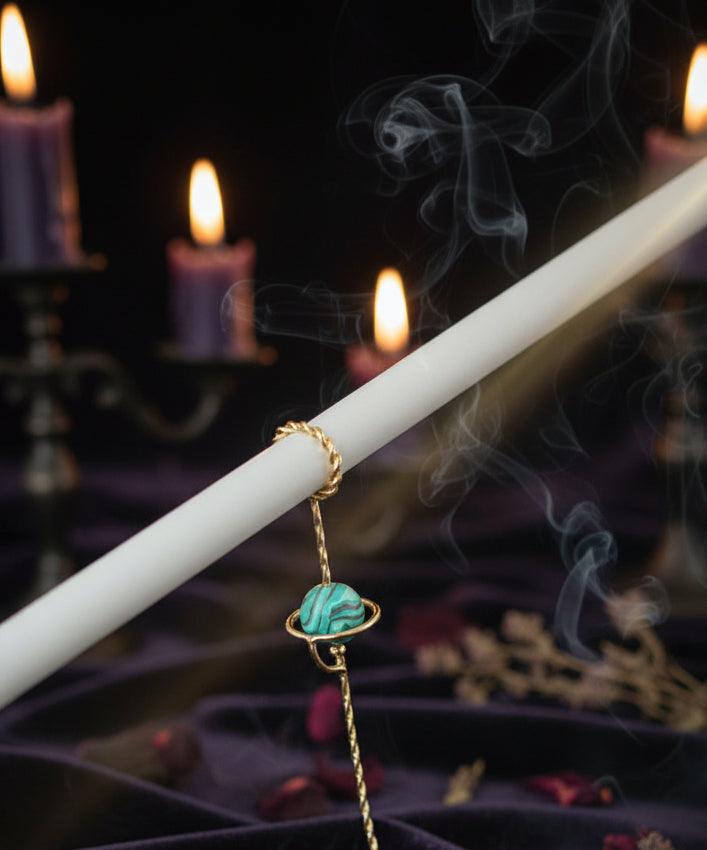 Gold bracelet with a turquoise stone on a white background