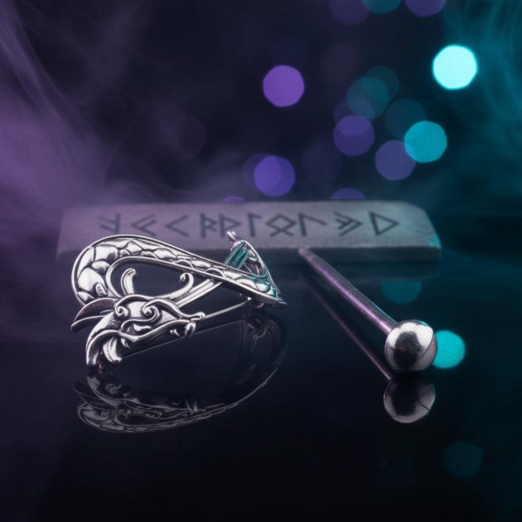 Silver dragon-shaped earring on a black background