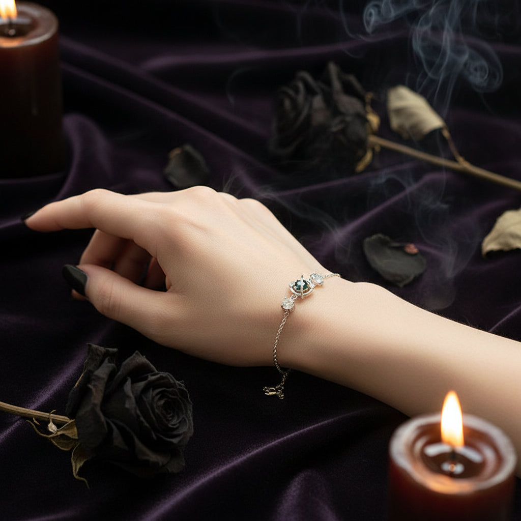 Silver bracelet with a green gemstone on a wrist against a soft, light background